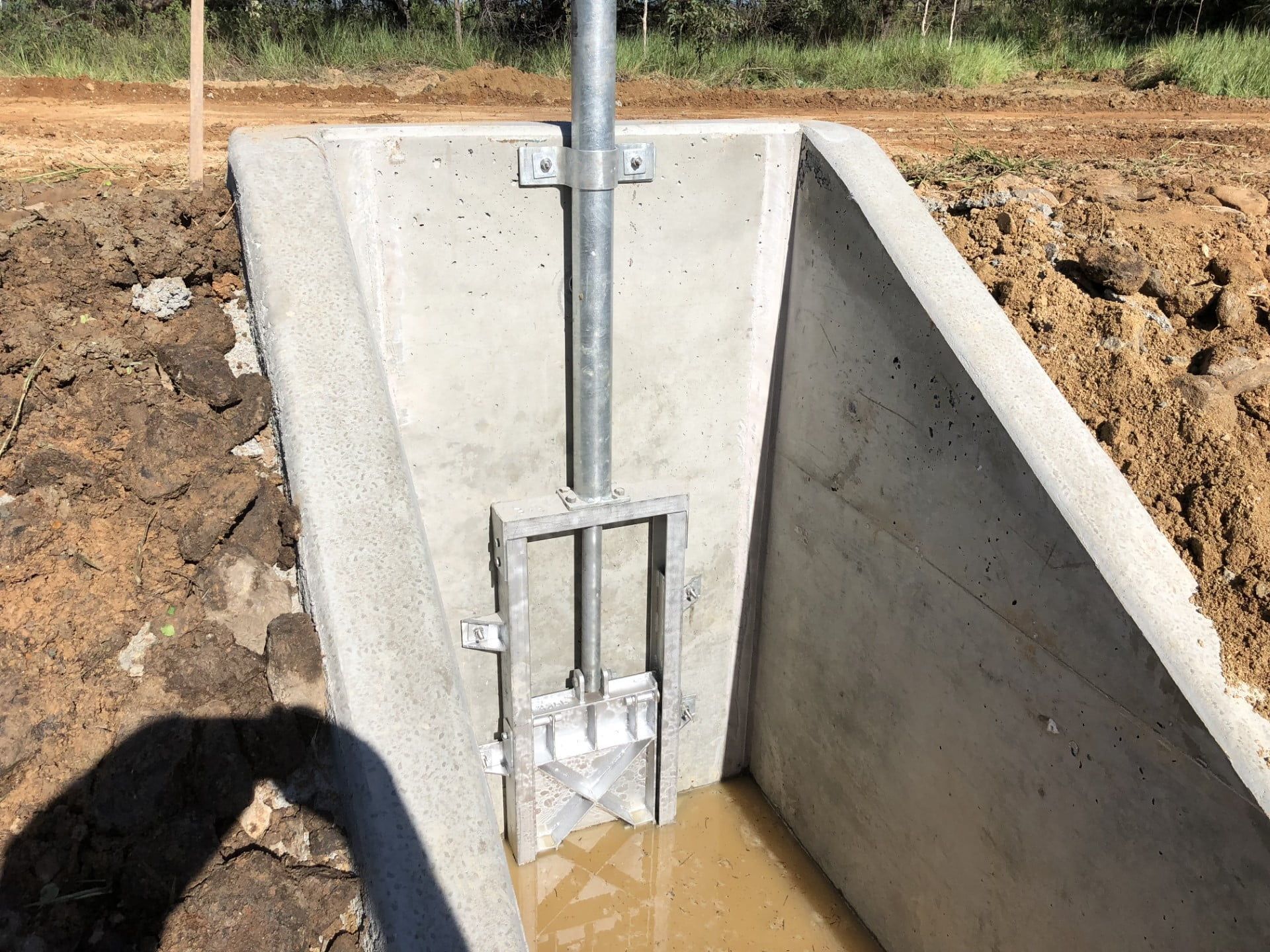 A Concrete Wall With A Metal Pipe Coming Out Of It — Neil Stafford Concreting In Mareeba, QLD