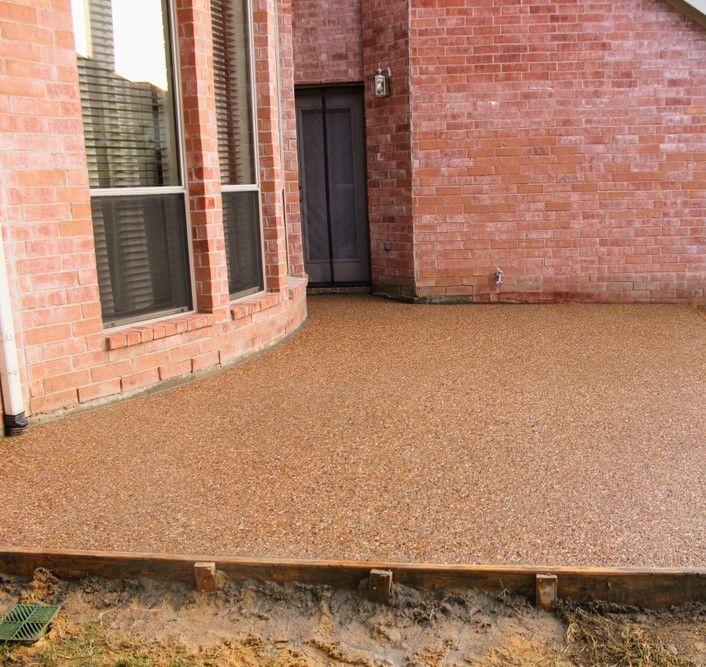 A Brick House With A Concrete Patio In Front Of It — Neil Stafford Concreting In Mareeba, QLD