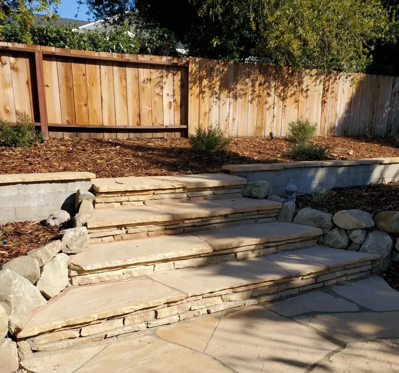 A stone staircase leading up to a wooden fence