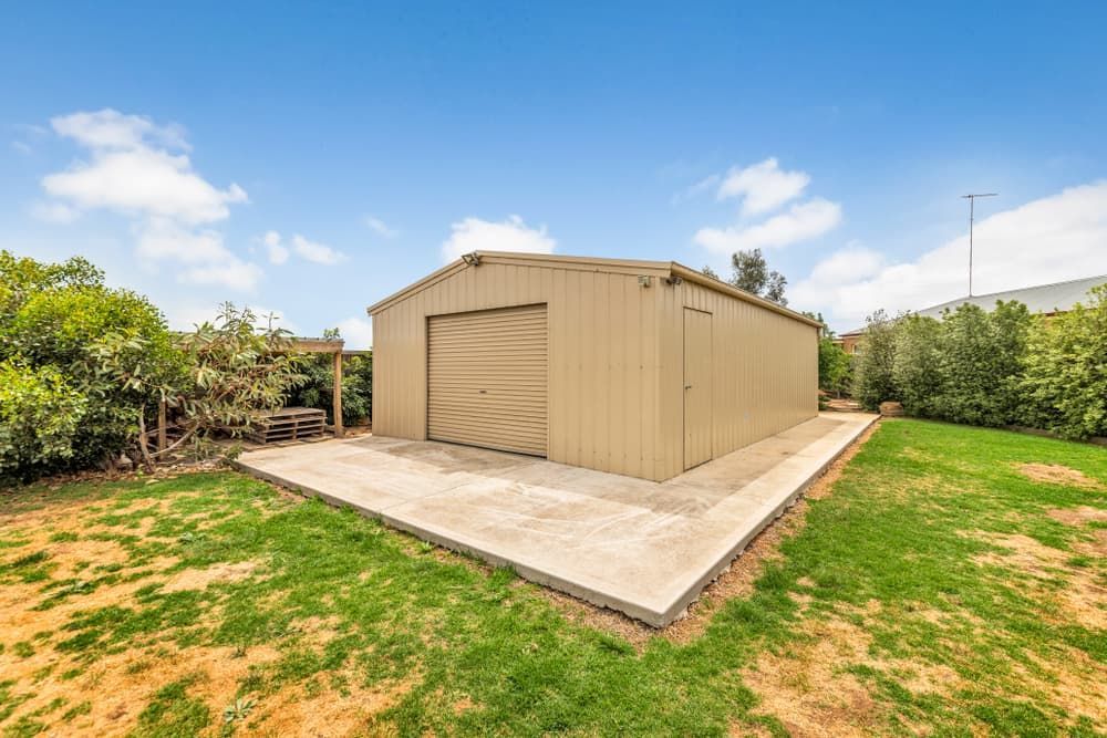A large shed is sitting in the middle of a lush green field. — Andrew Logan Building In Dubbo, NSW