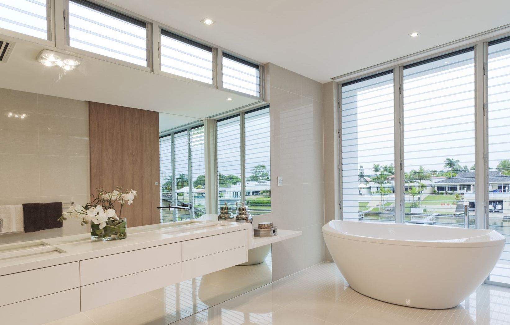 A bathroom with a tub , sink , mirror and large windows.  — Andrew Logan Building In Narromine, NSW
