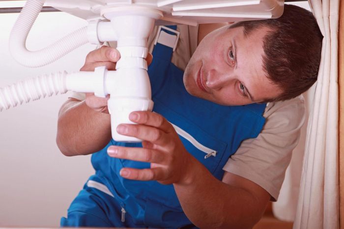photo of plumber fixing sink drain