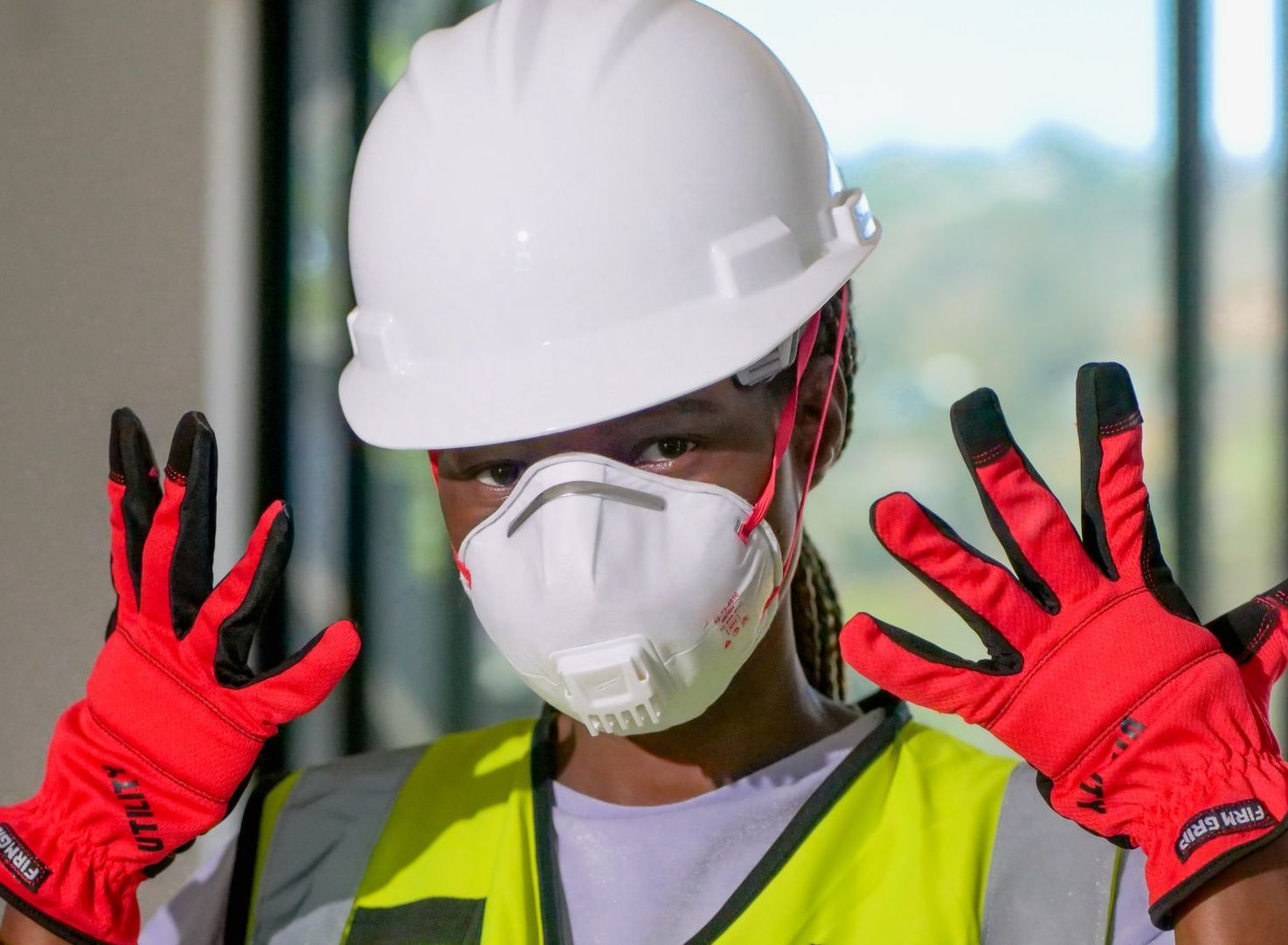 picture of handyperson with gloves, mask and hardhat on.