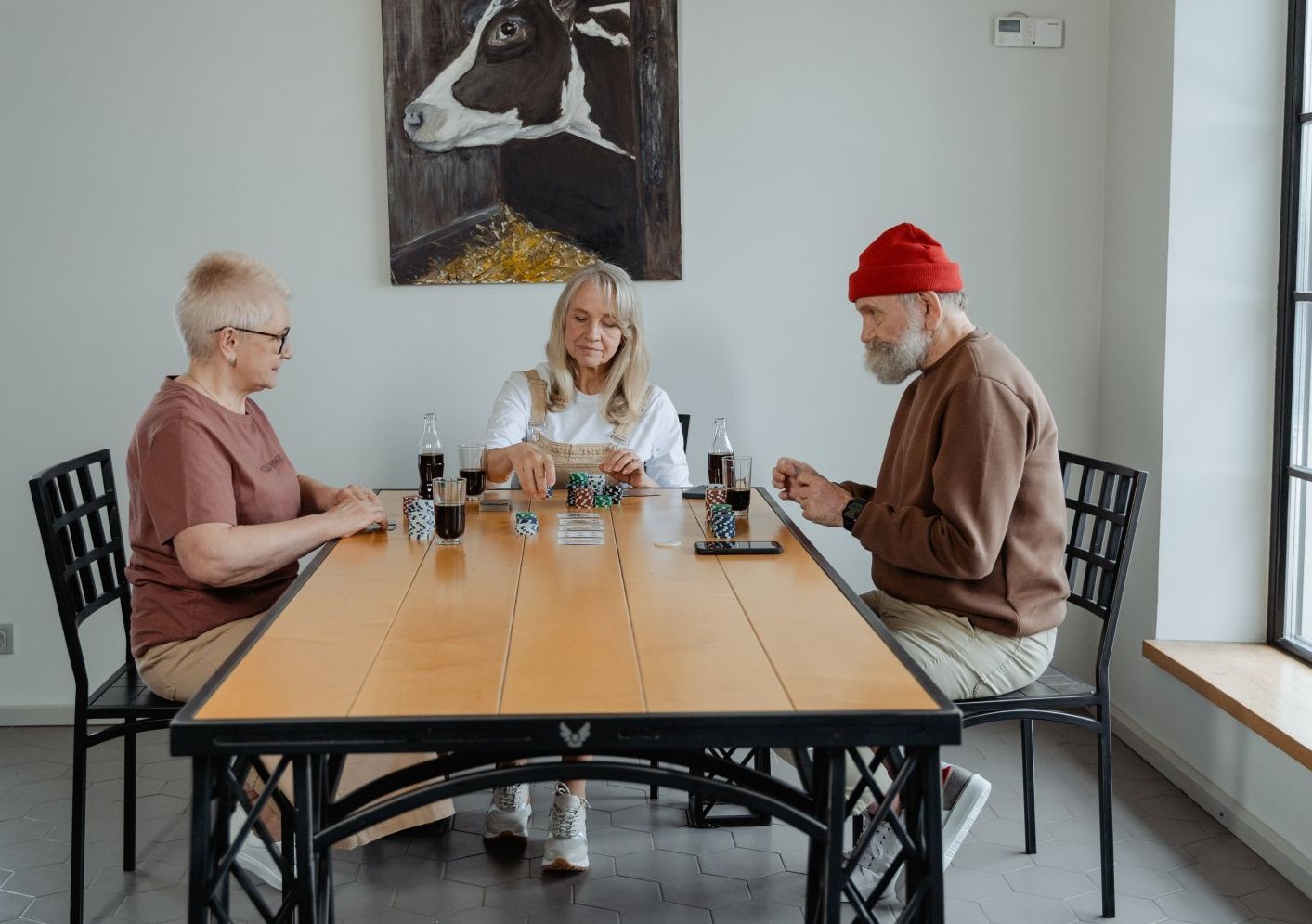 picture of 3 elderly people gathered around wooden table