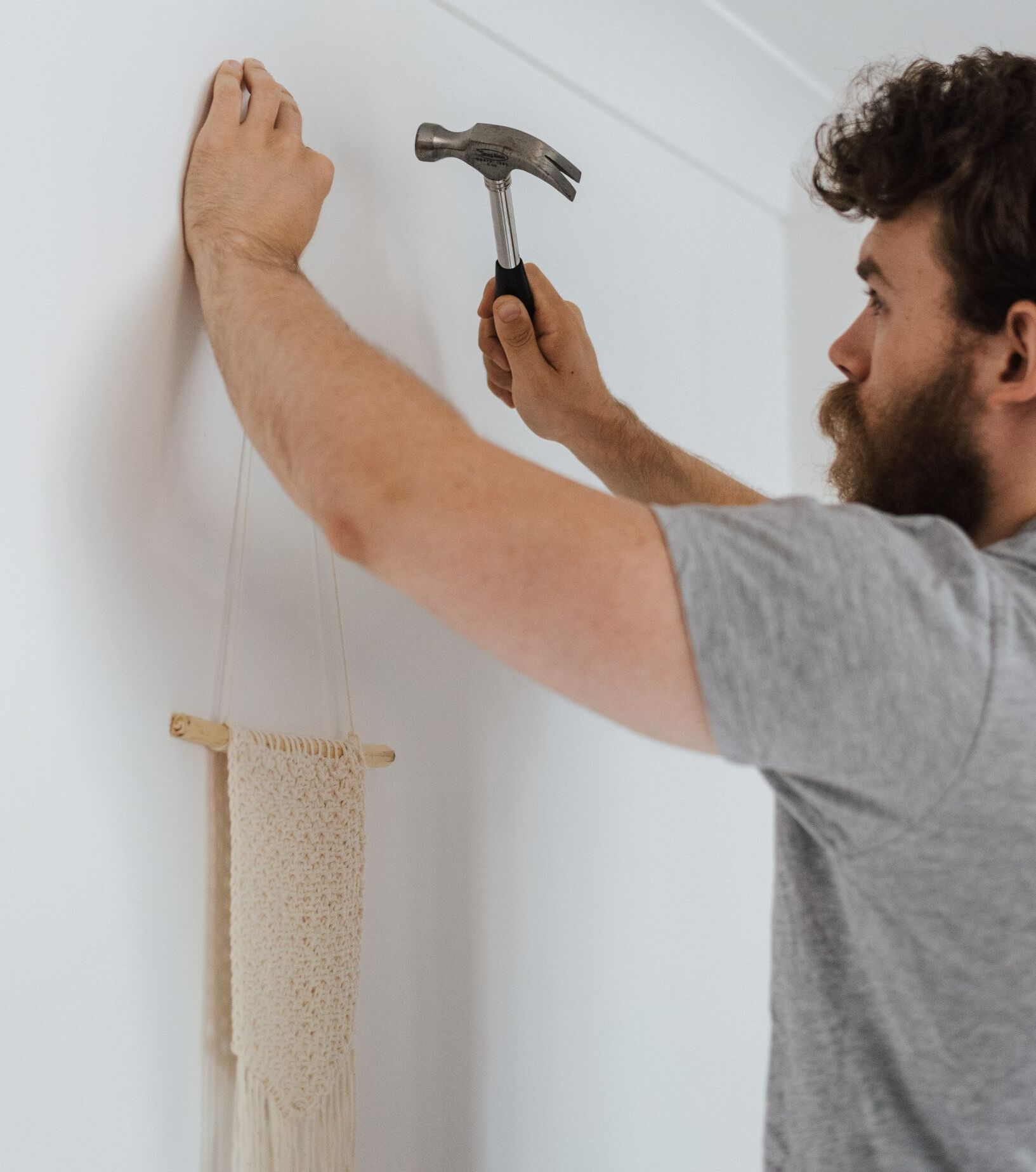 picture of man using hammer on wall