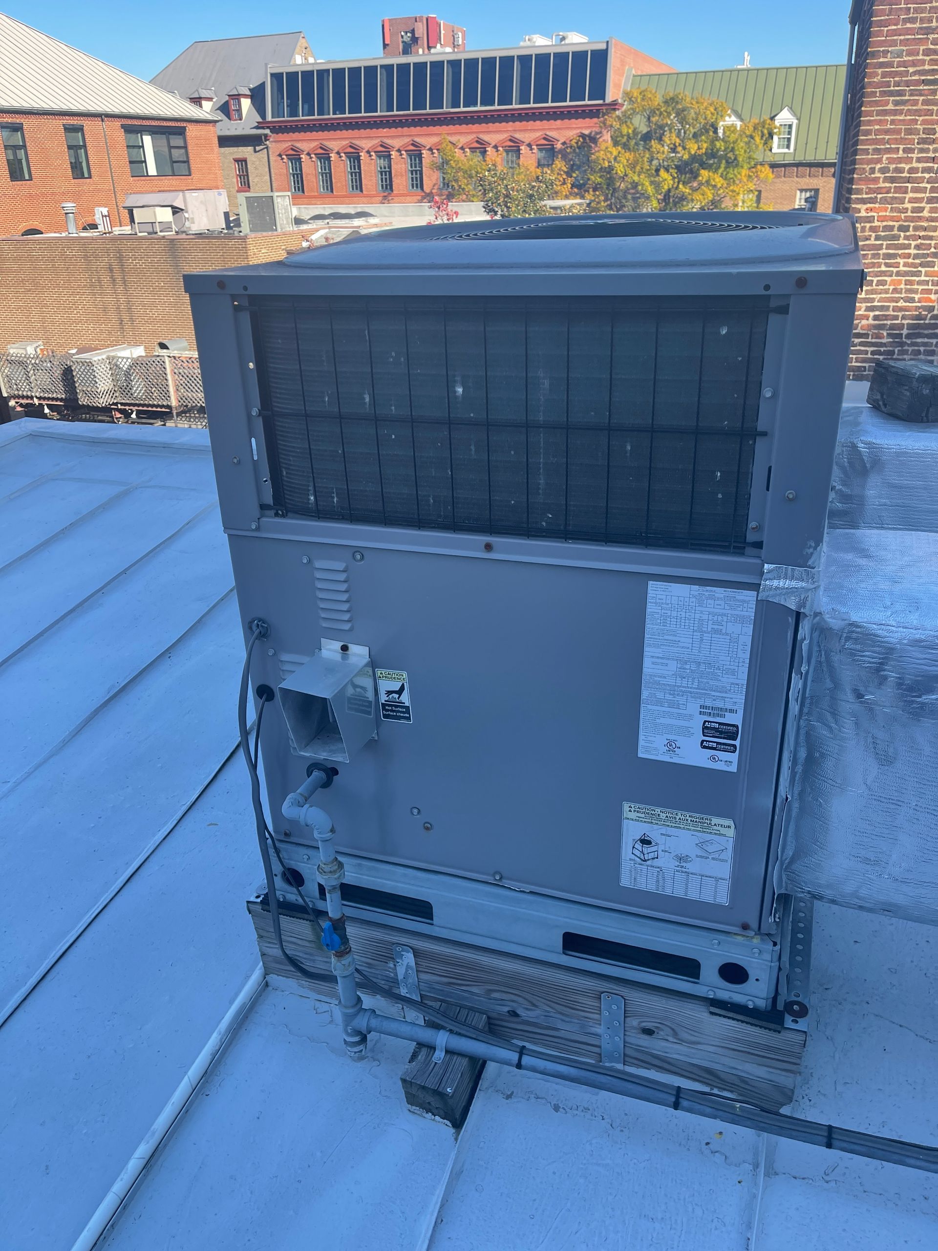 A large air conditioner is sitting on top of a roof.