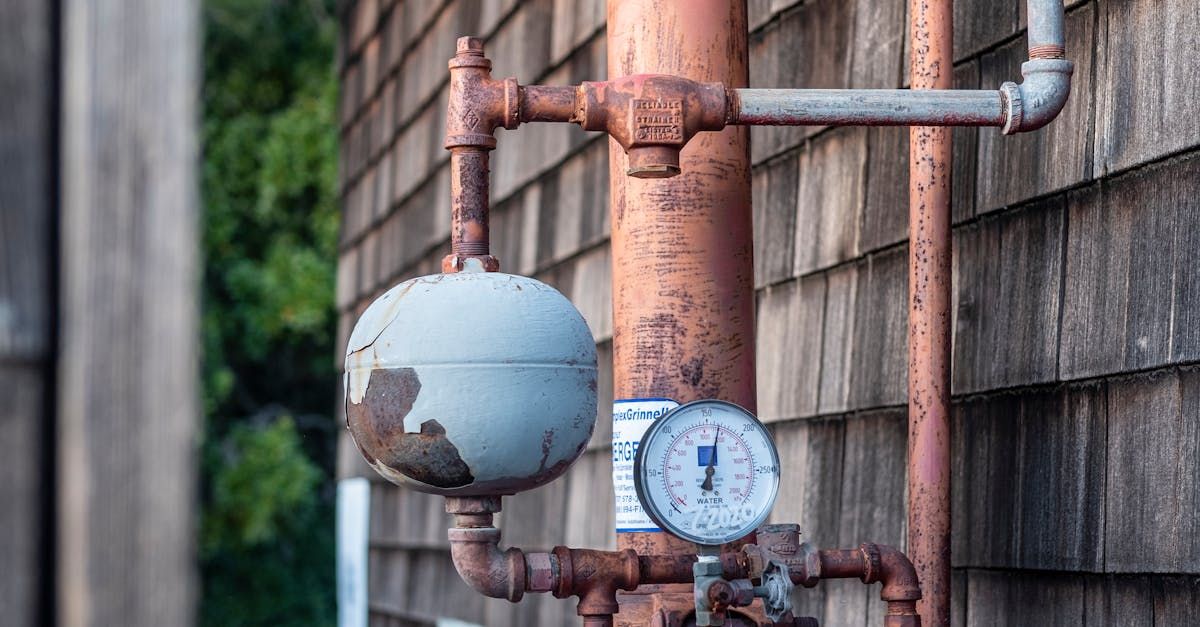 A close up of a copper pipe with a pressure gauge attached to it.