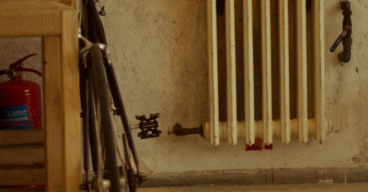 A bicycle is leaning against a wall next to a radiator.