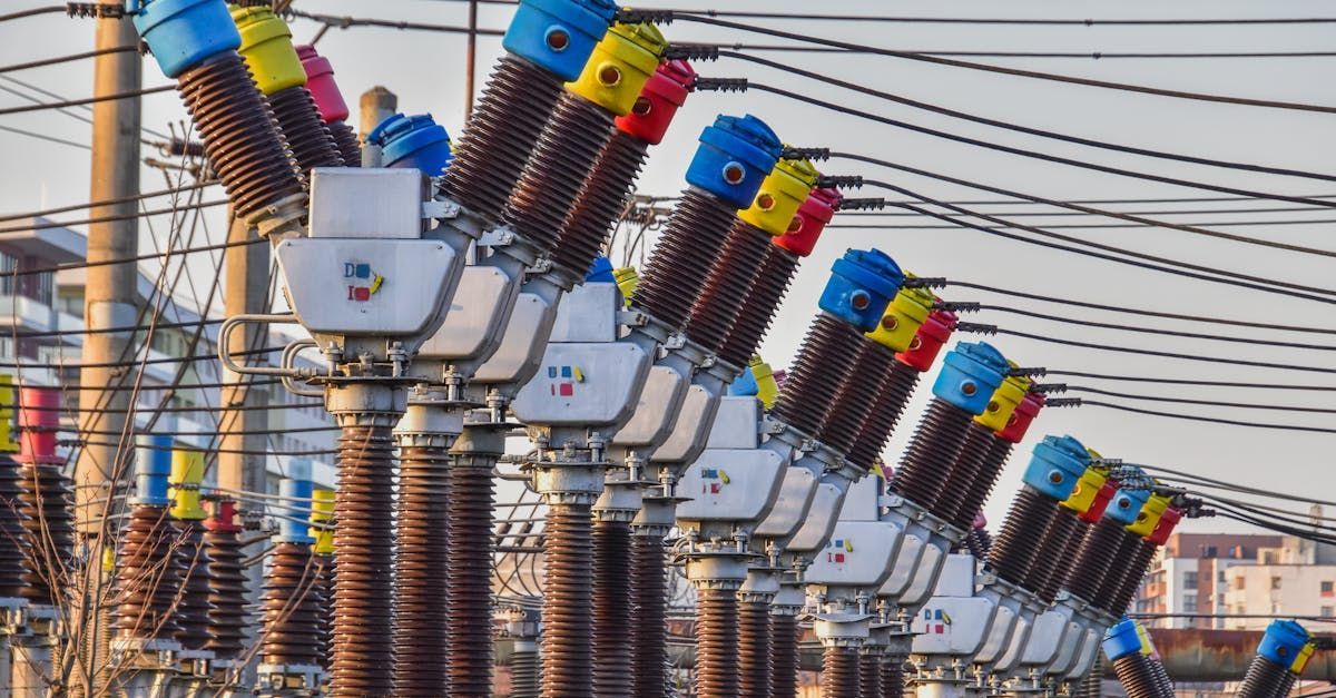 A bunch of electrical transformers are sitting on top of power lines.