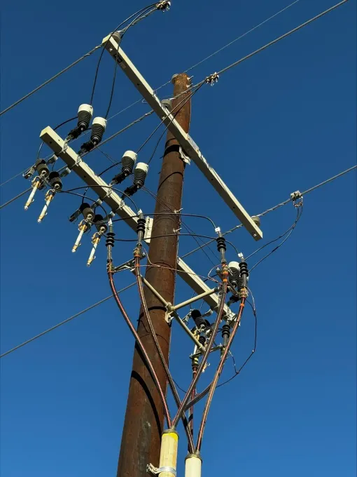 A telephone pole with a blue sky in the background