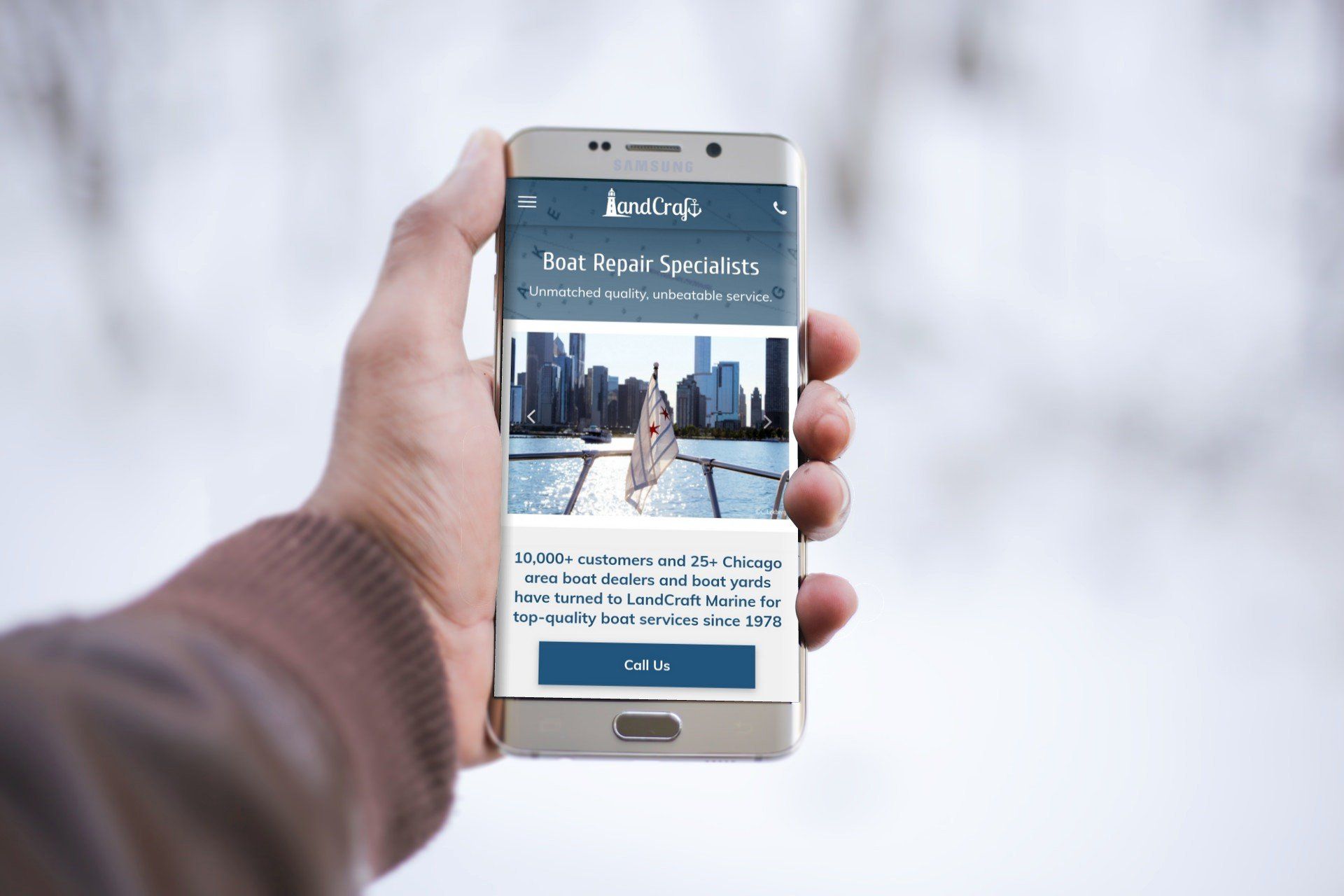 Person holding a smart phone showing LandCraft website on screen