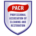 Logo for Professional Association of Cleaning and Restoration (PACR). White and blue shield with a red banner.