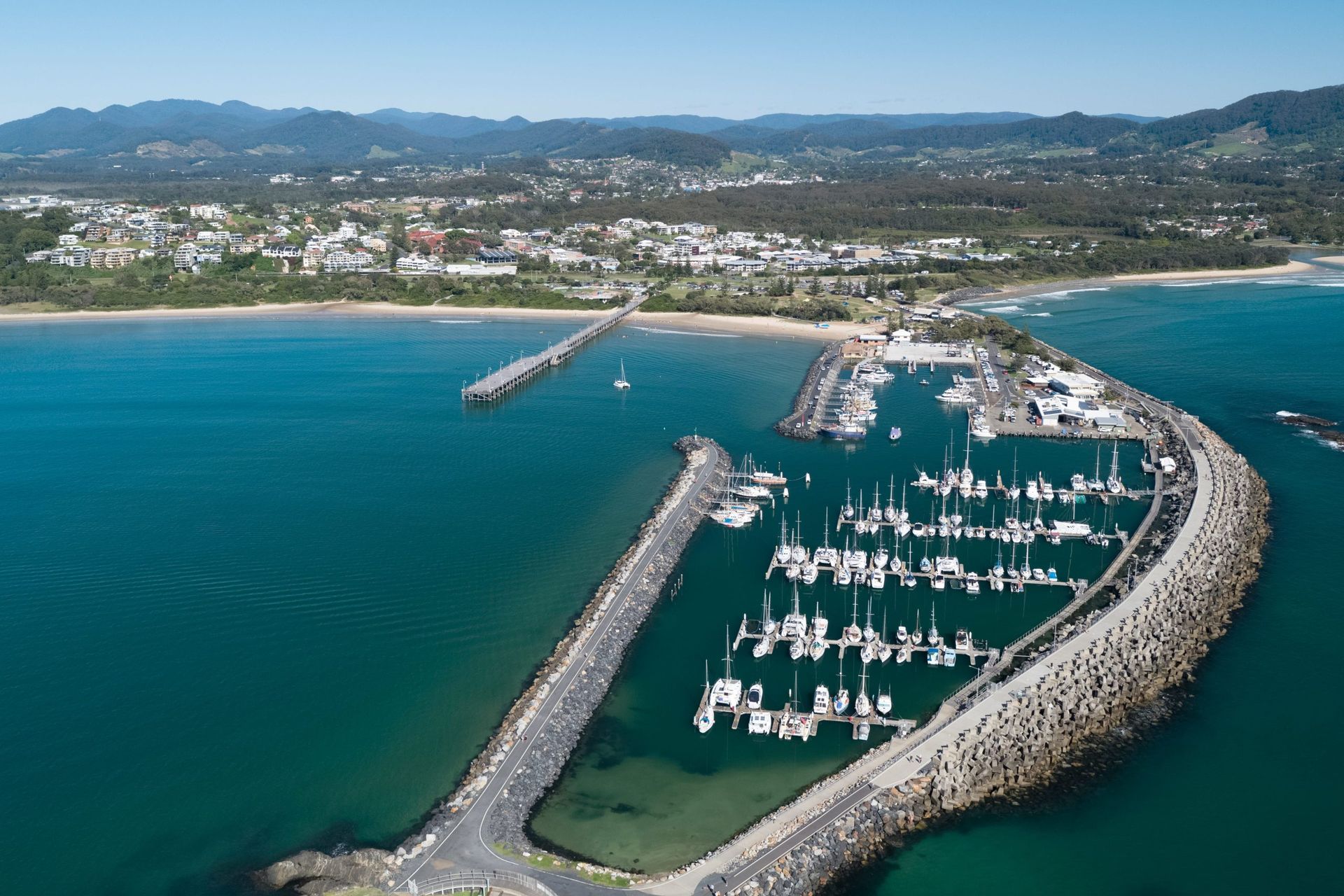 A Pier Leading Into The Ocean With Yachts— Torque Tech Supply & Repairs In Coffs Harbour, NSW