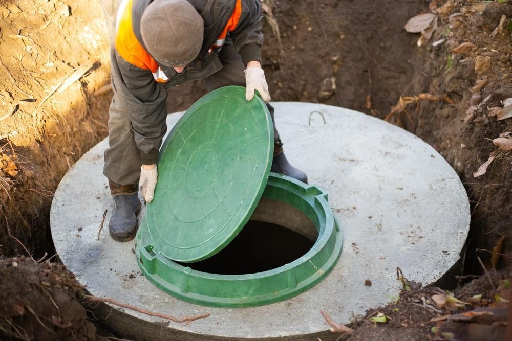 A Man Is Opening The Lid Of A Septic Tank — Torque Tech Supply & Repairs In Taree, NSW
