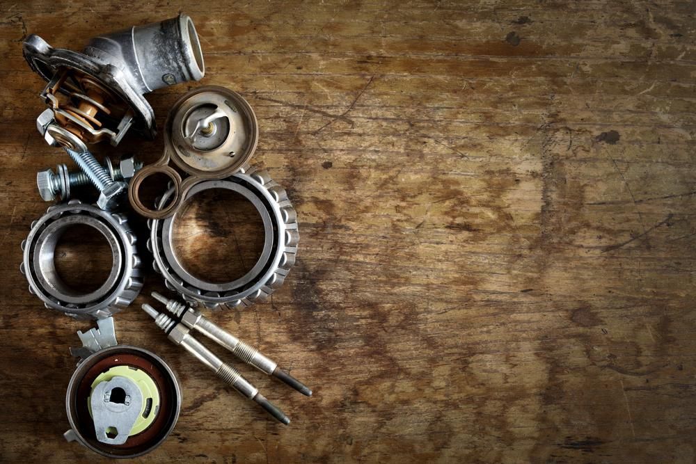 A Bunch Of Metal Parts Are On A Wooden Table — Torque Tech Supply & Repairs In Port Macquarie, NSW