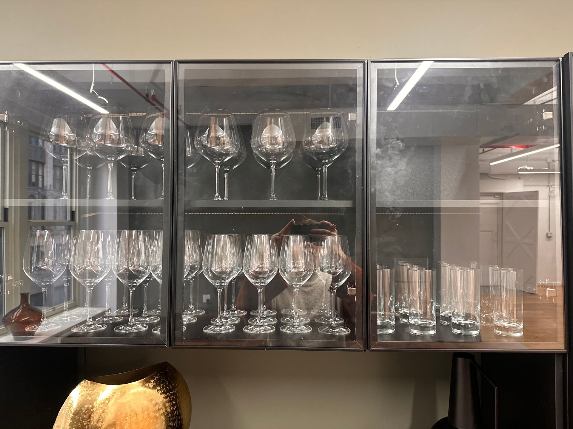 A glass cabinet filled with lots of wine glasses