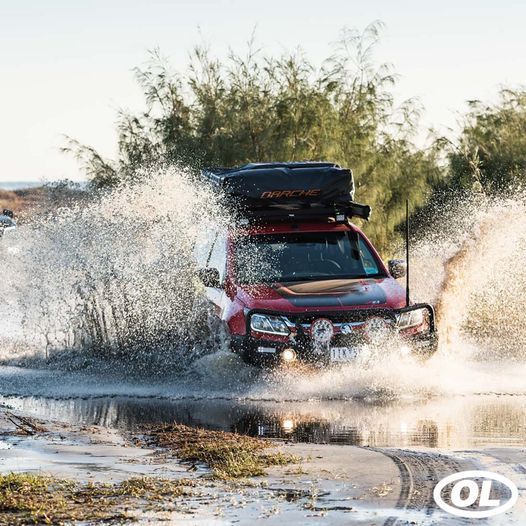 A Red SUV Is Driving Through A Puddle Of Water — Opposite Lock In Wodonga, VIC