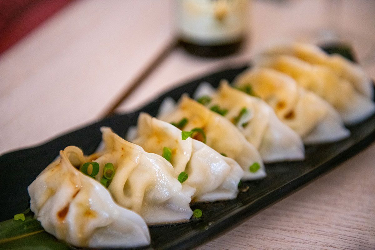 A close up of a plate of dumplings on a table.