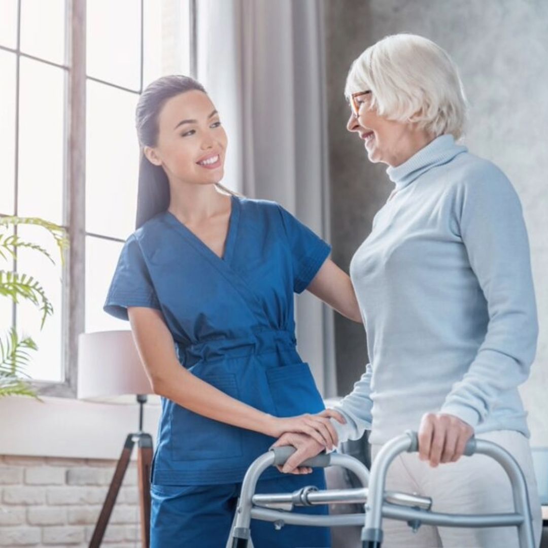 A nurse is helping an elderly woman with a walker.