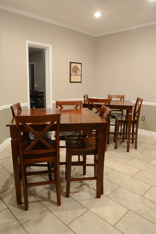 A dining room with tables and chairs and a picture on the wall