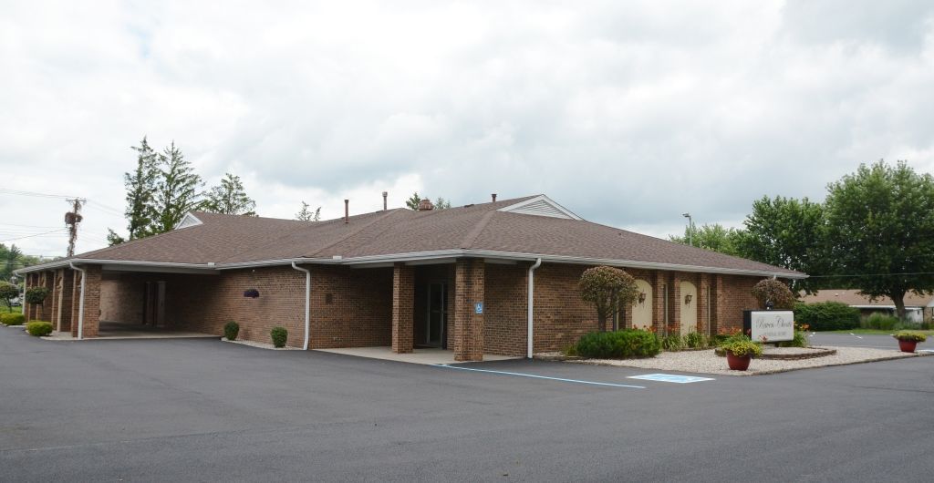 A large brick building with a parking lot in front of it