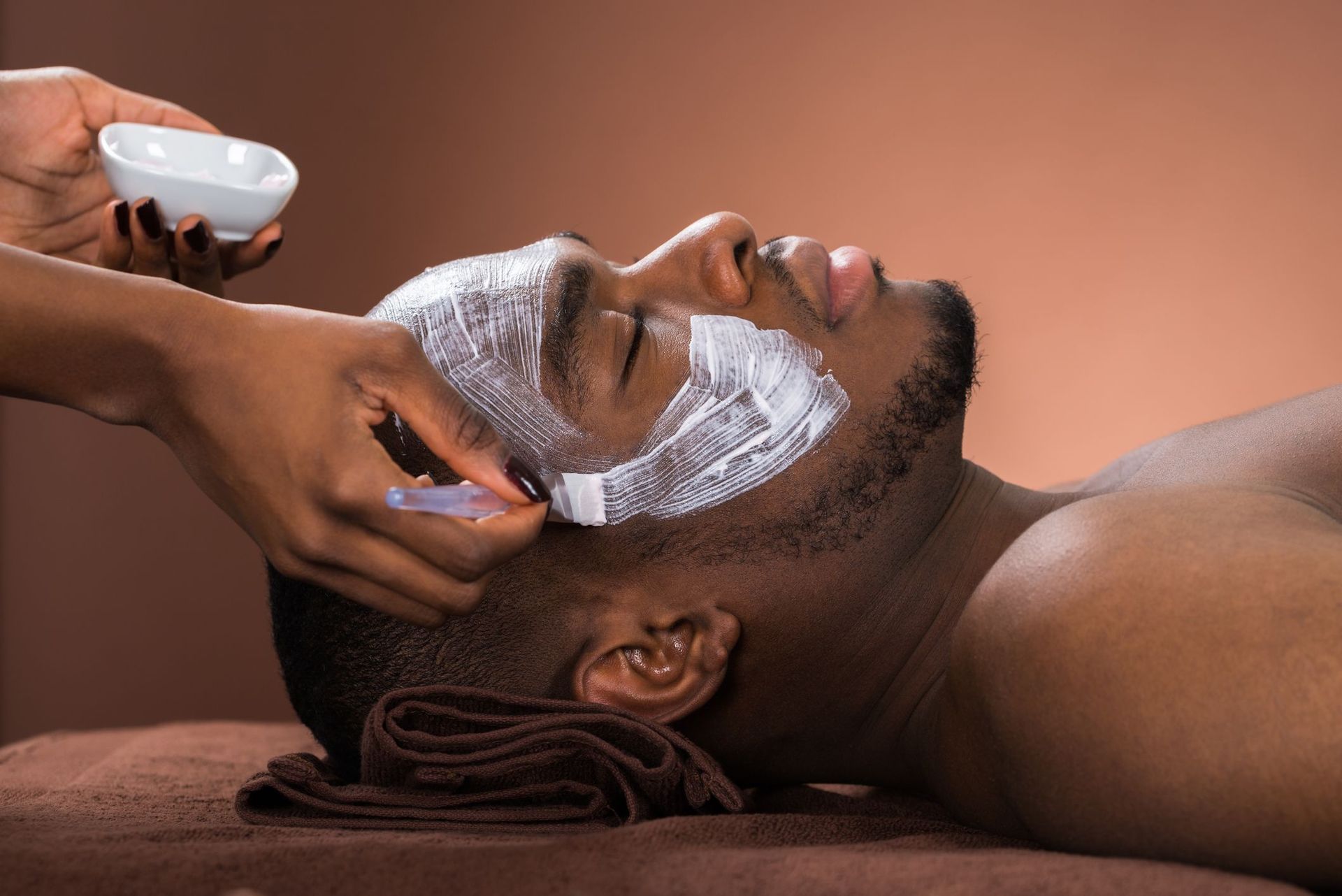 A man is getting a facial treatment at a spa.