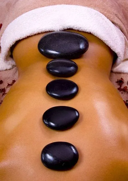A person is getting a hot stone massage on their back
