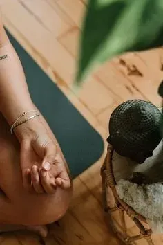 A woman is sitting on a yoga mat next to an avocado
