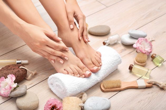 A woman is sitting on the floor with her feet on a towel