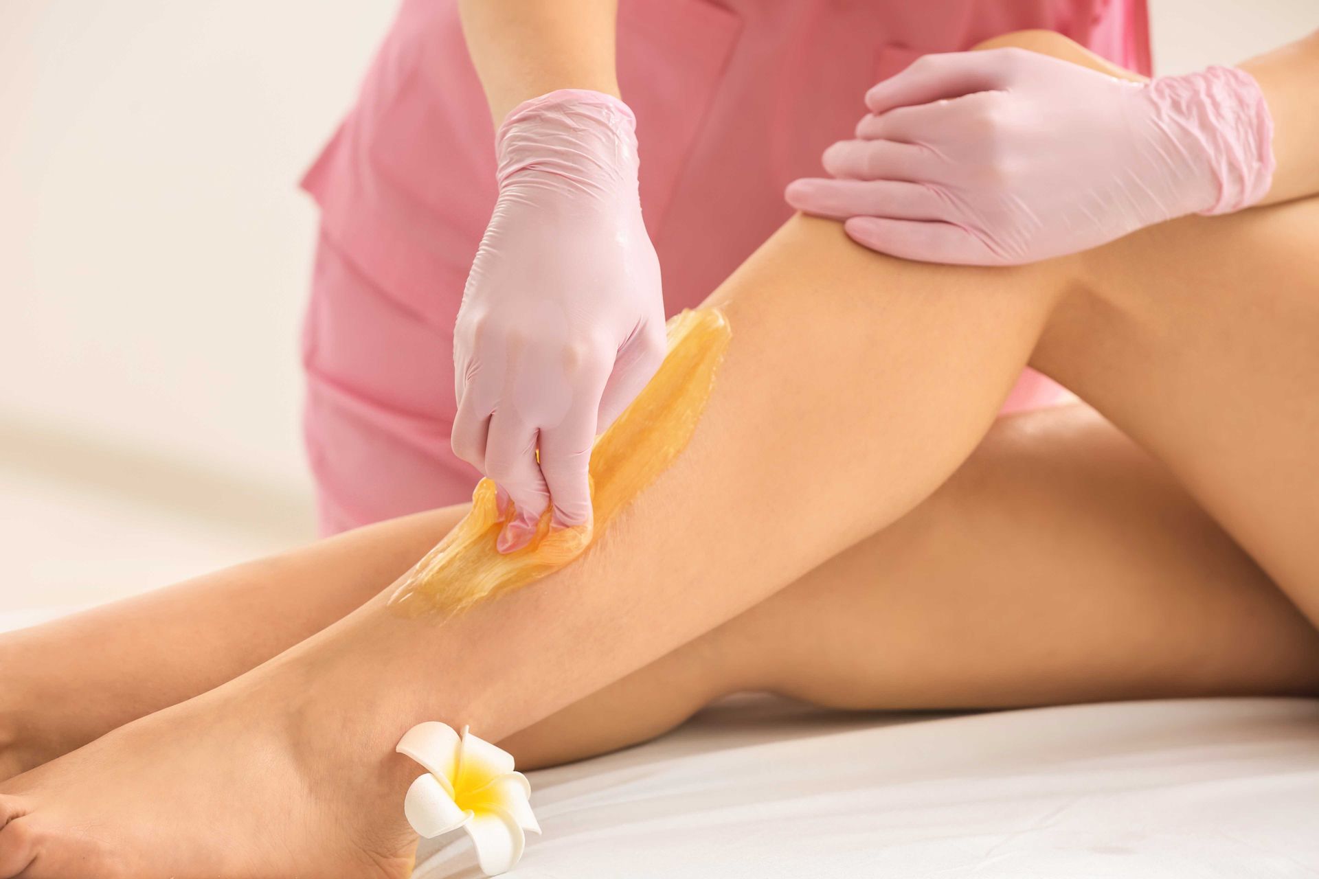 A woman is getting her legs waxed in a beauty salon