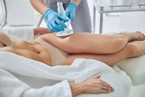 A woman is getting an ultrasonic cavitation treatment on her legs