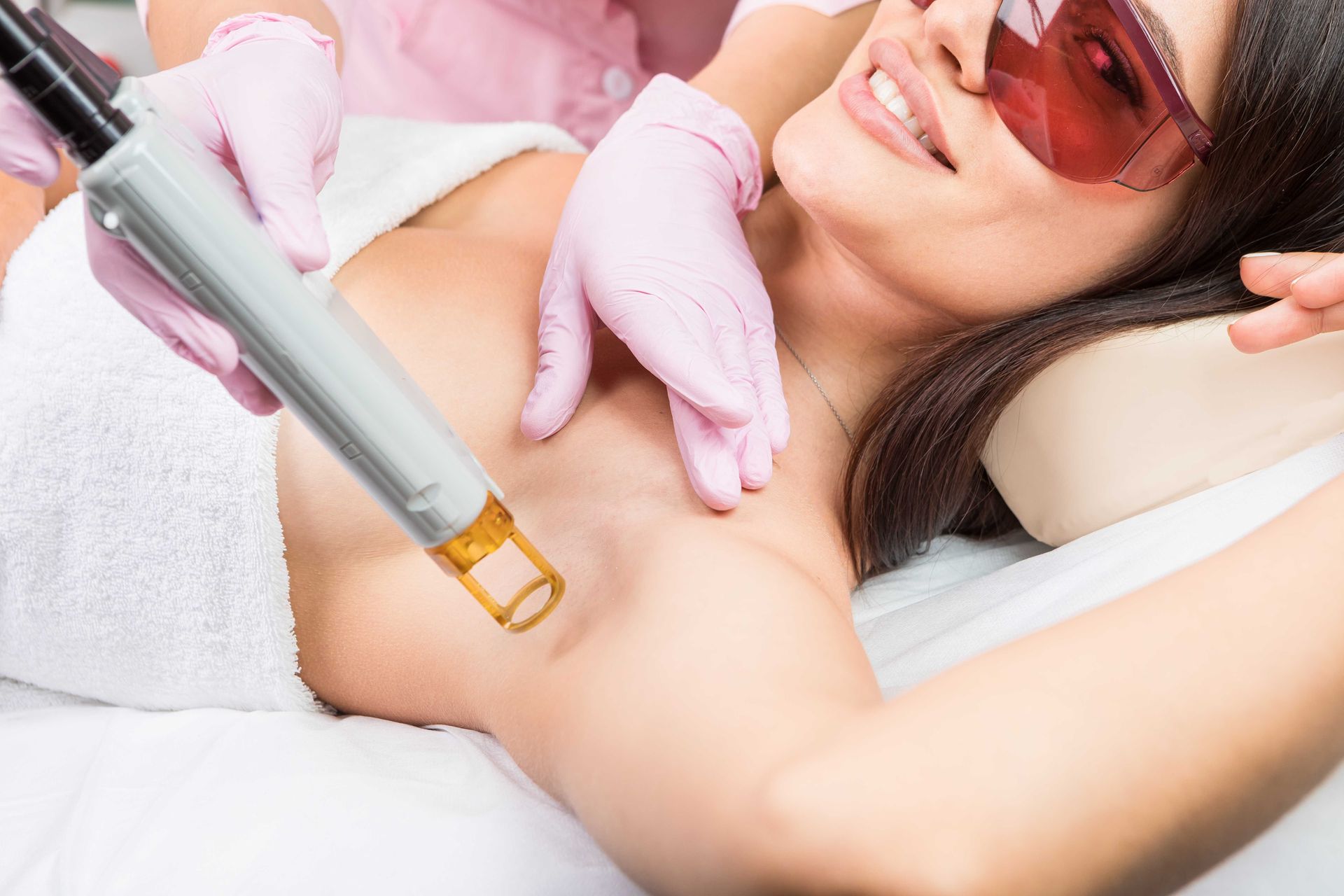 A woman is getting a laser hair removal treatment on her armpit