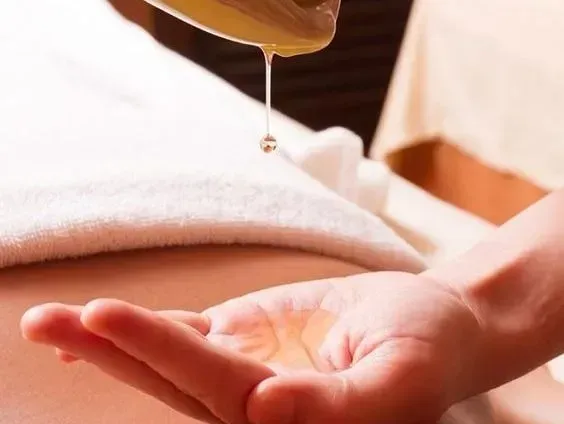A person is getting a massage with oil on their hand