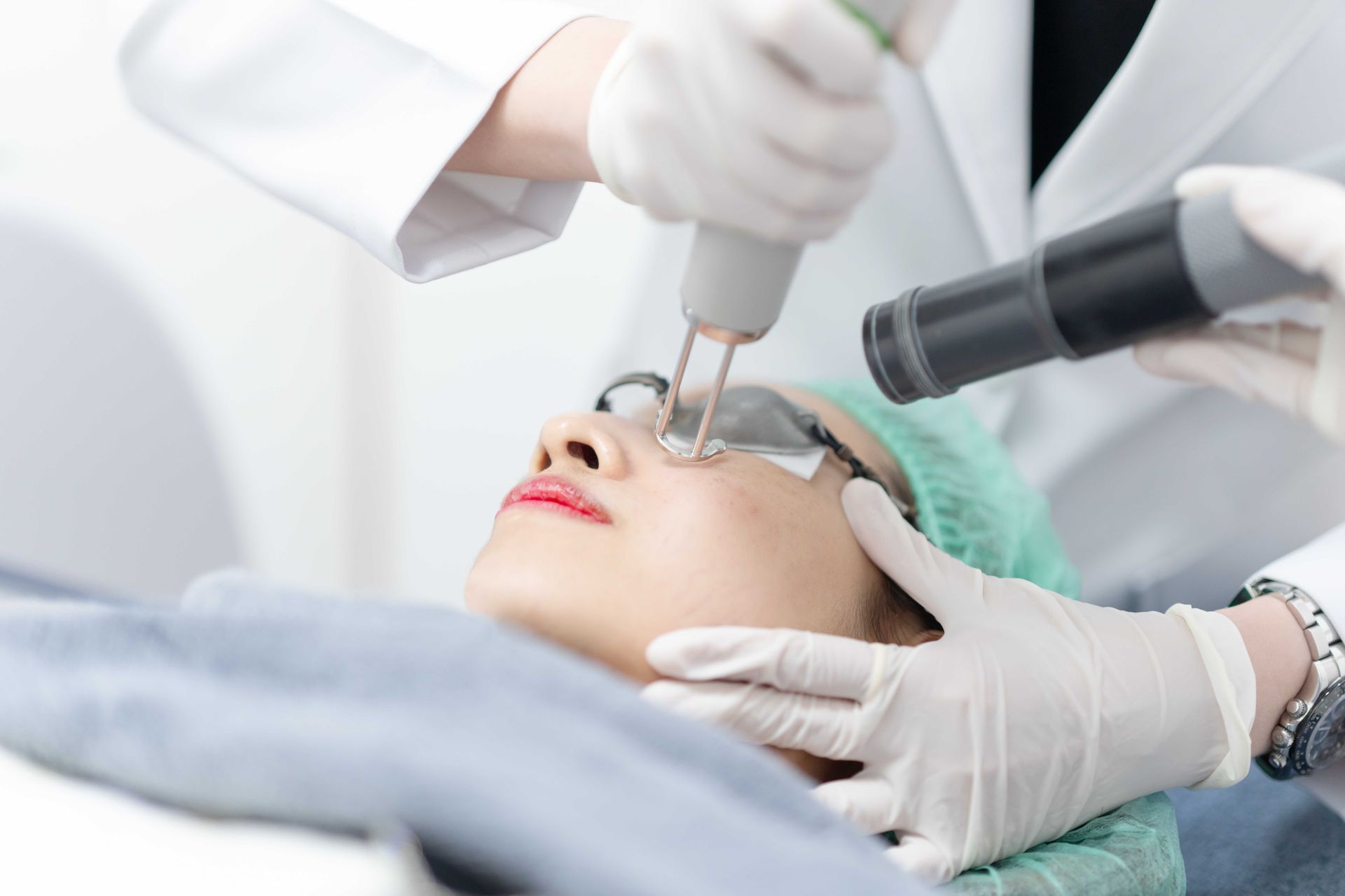 A woman is getting a laser treatment on her face