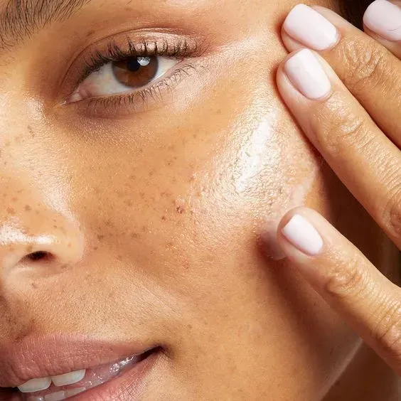 A close up of a woman 's face with her hands on it