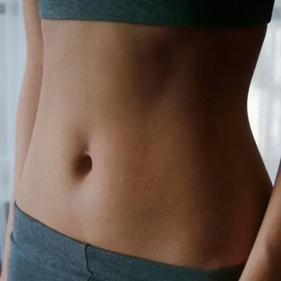 A close up of a woman 's stomach in a sports bra and shorts