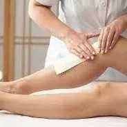 A woman is getting her legs waxed at a spa