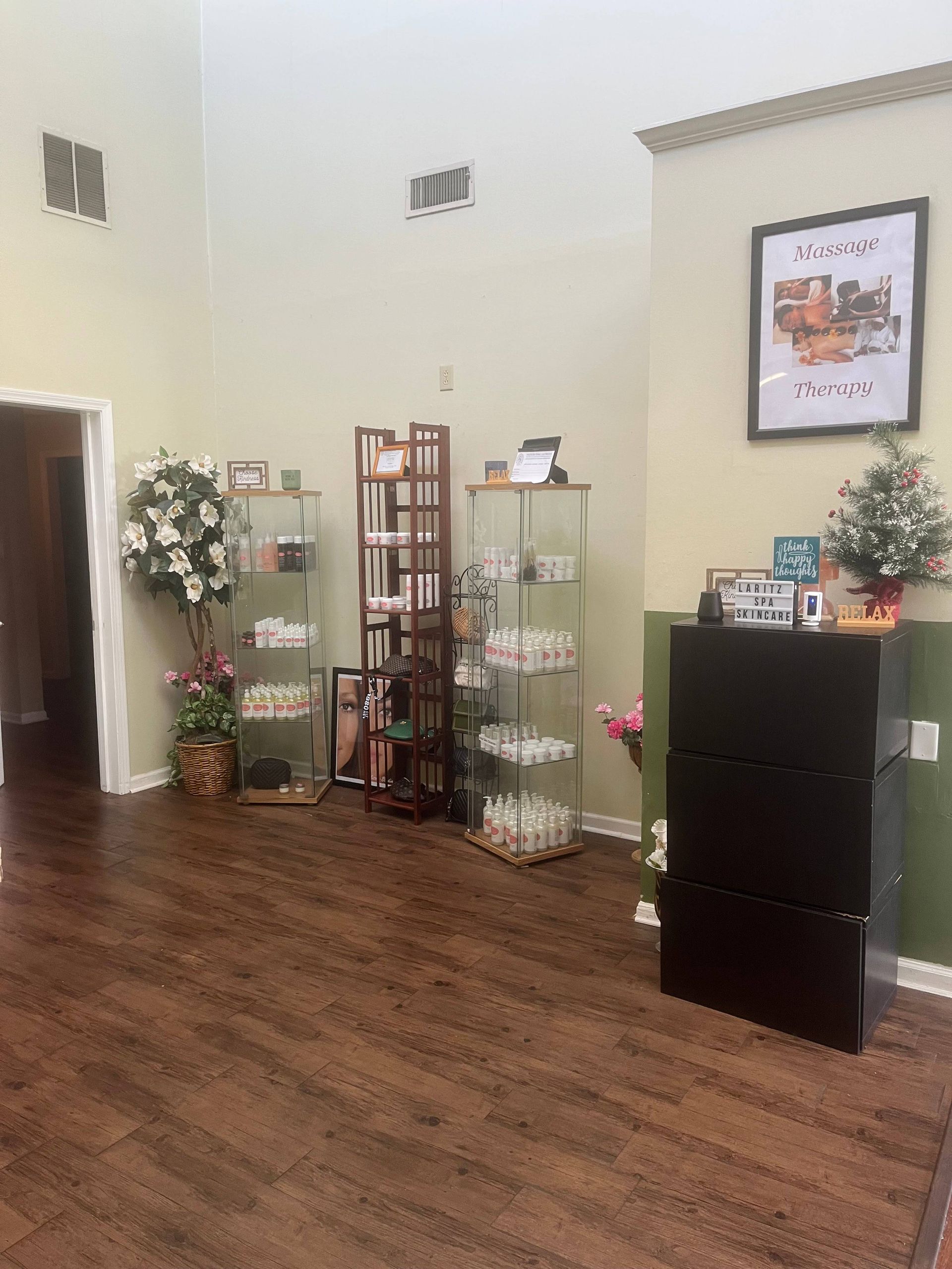 A room with a wooden floor and a shelf with flowers on it.