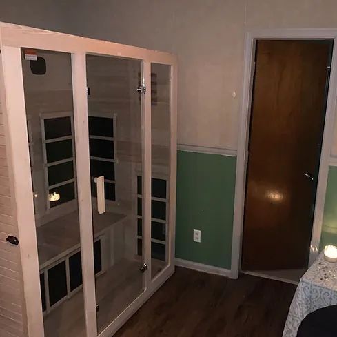 A room with a sauna , a table and a door.