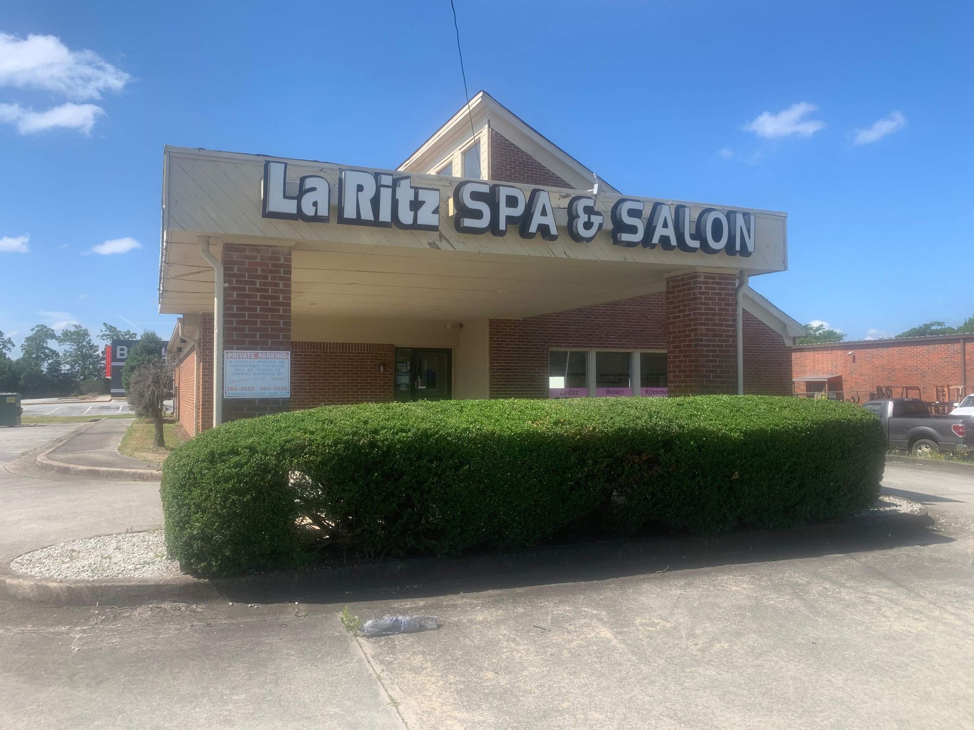 The front of a la rita spa and salon with a hedge in front of it.