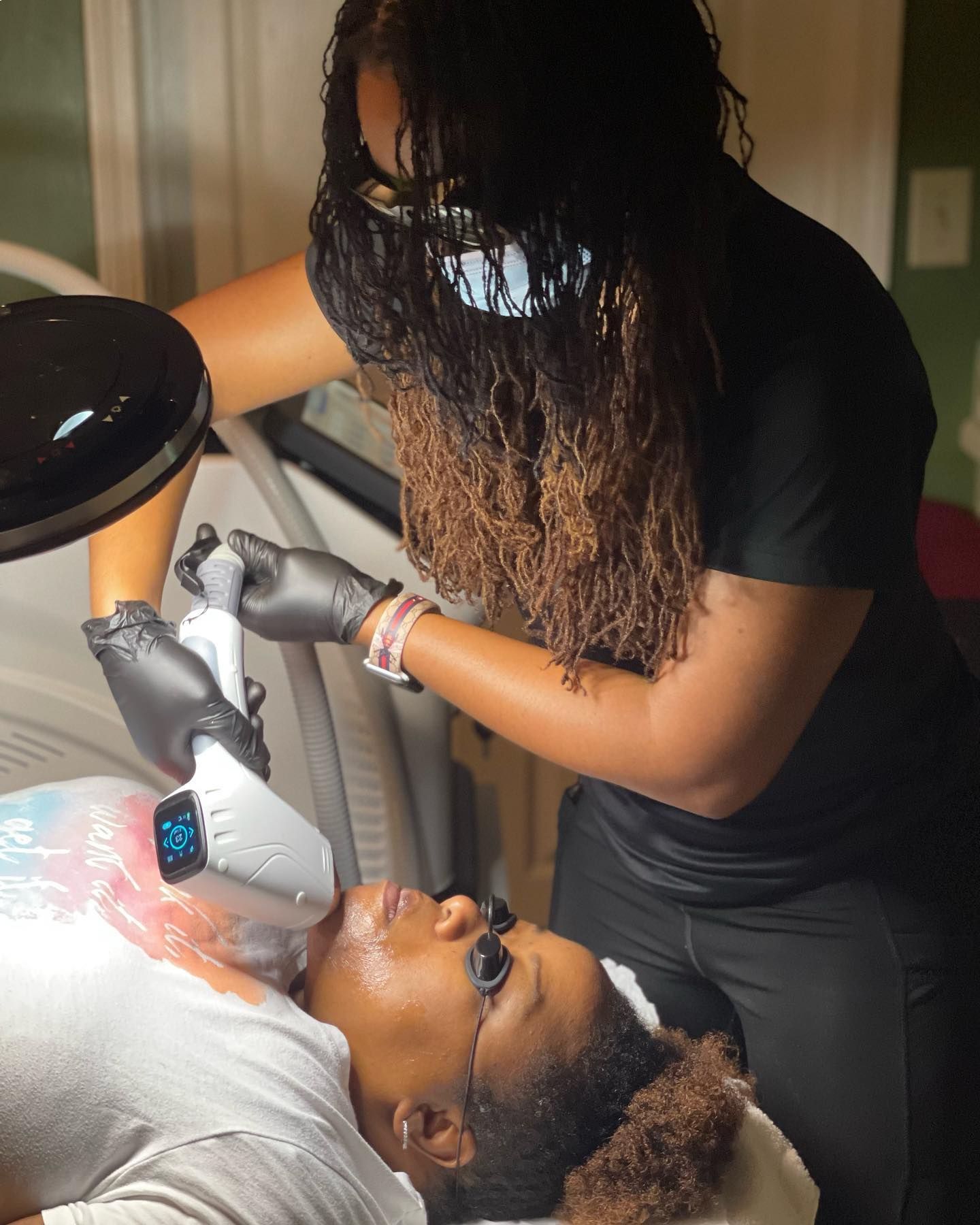 A woman is getting a laser treatment on her neck.