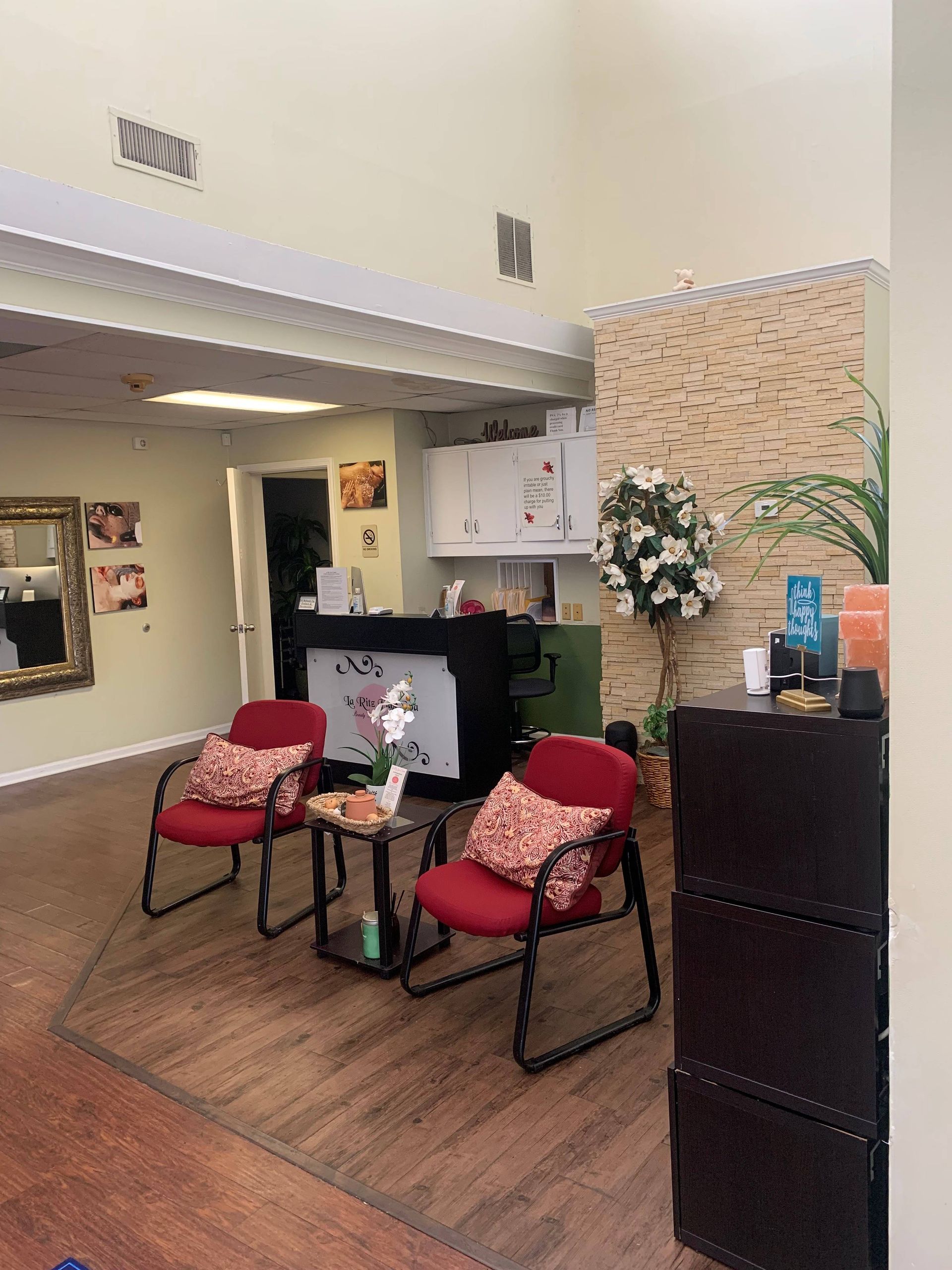 A waiting room with red chairs and a table