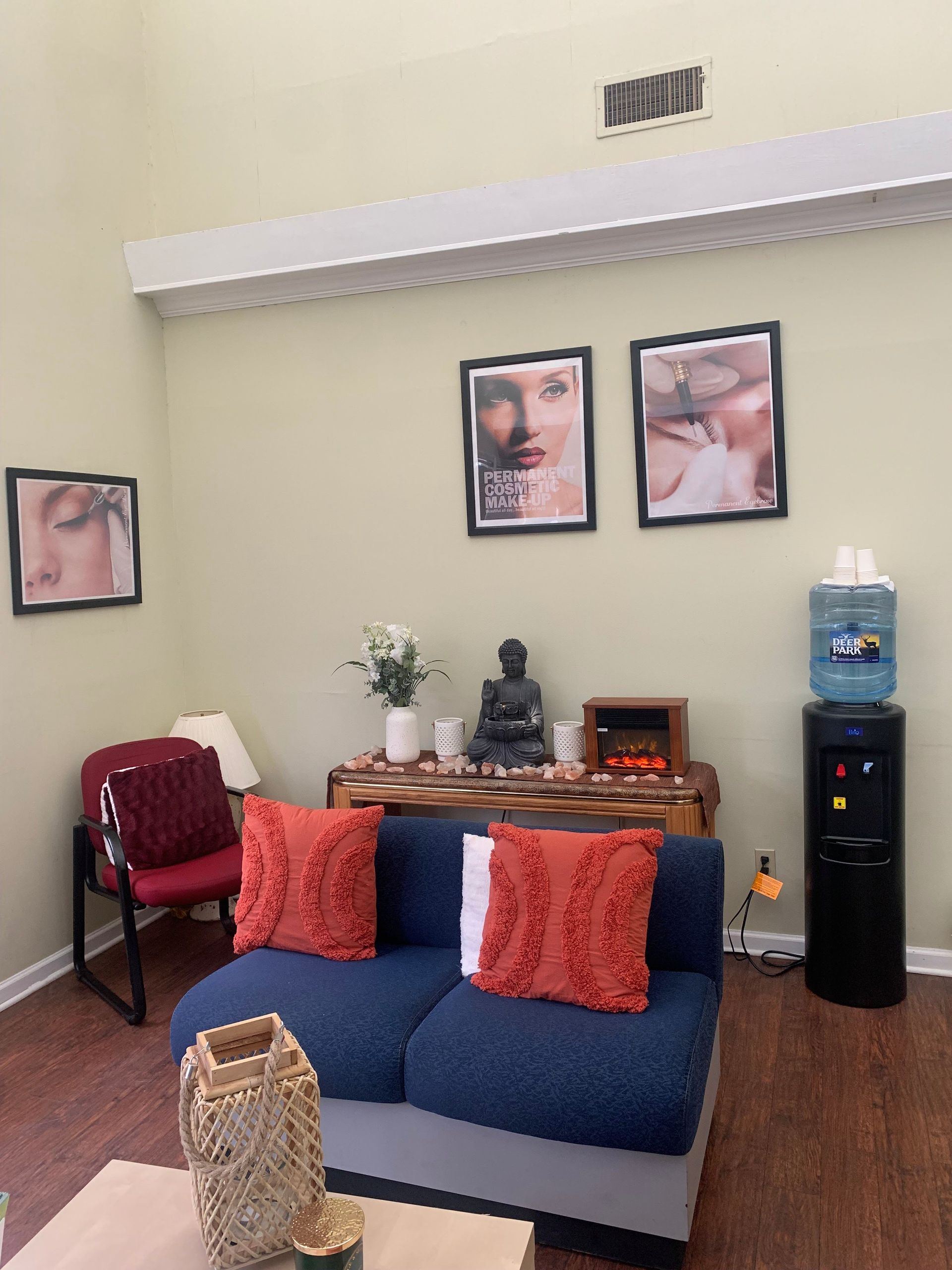 A living room with a blue couch and two pictures on the wall