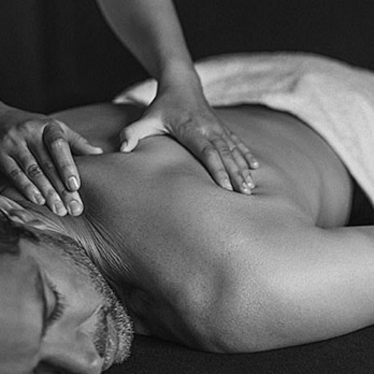 A black and white photo of a man getting a massage.