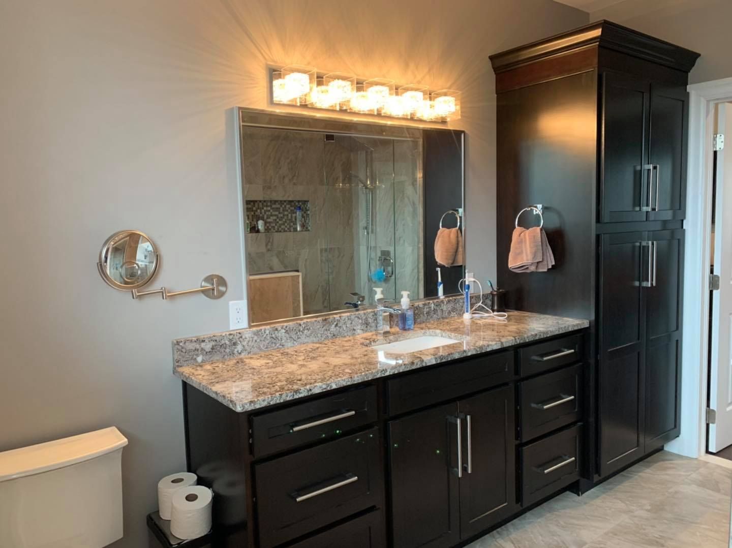 A bathroom with two sinks , a toilet and a mirror.