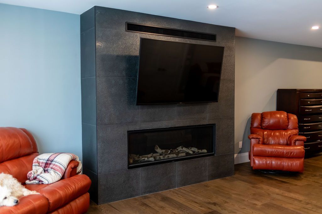 A living room with a fireplace and a flat screen tv.
