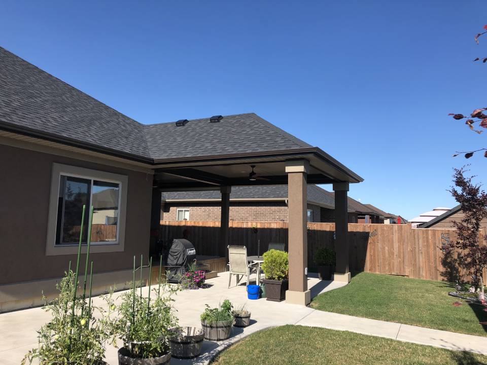 The backyard of a house with a patio and a grill.