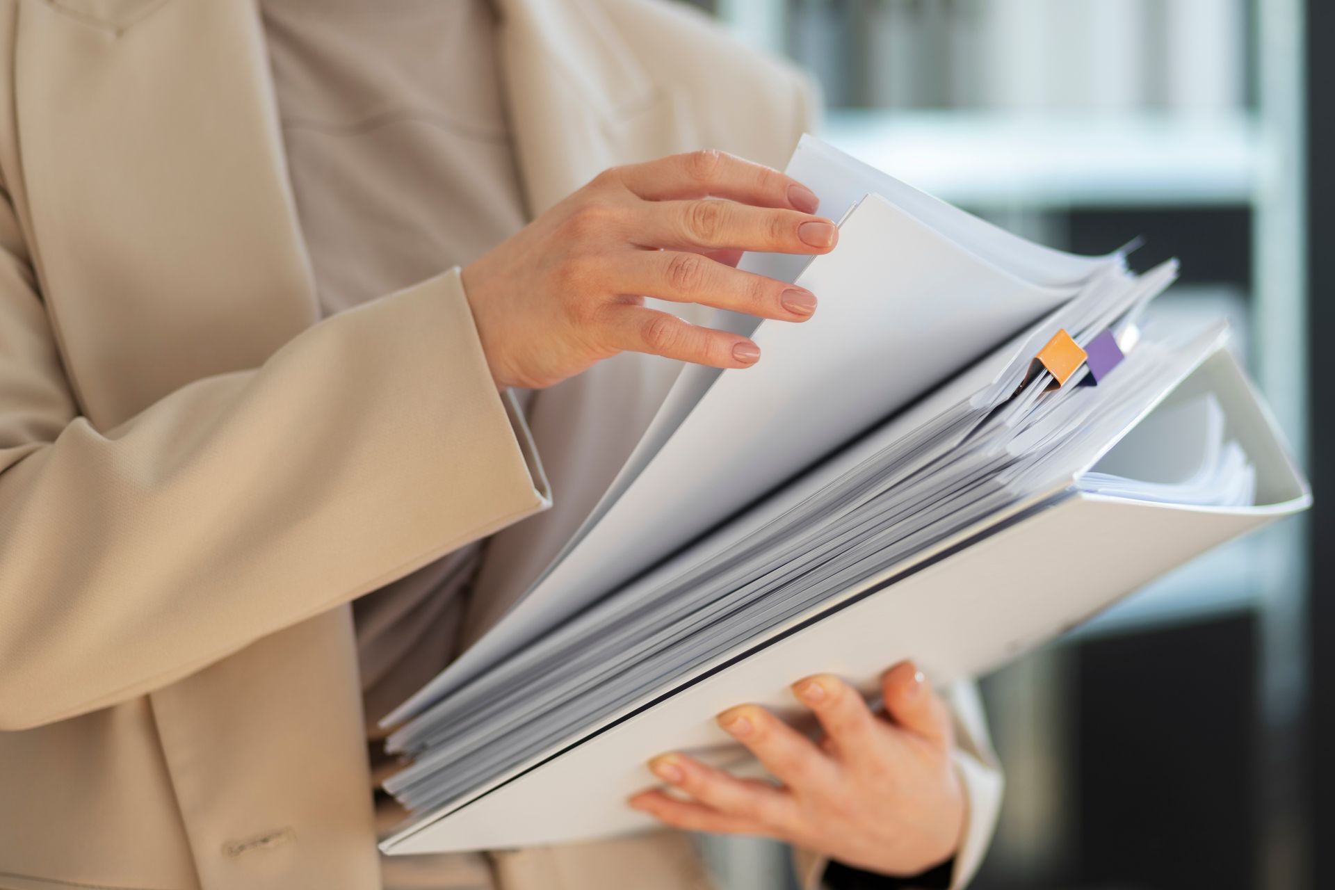 A woman is holding a stack of papers in her hands.