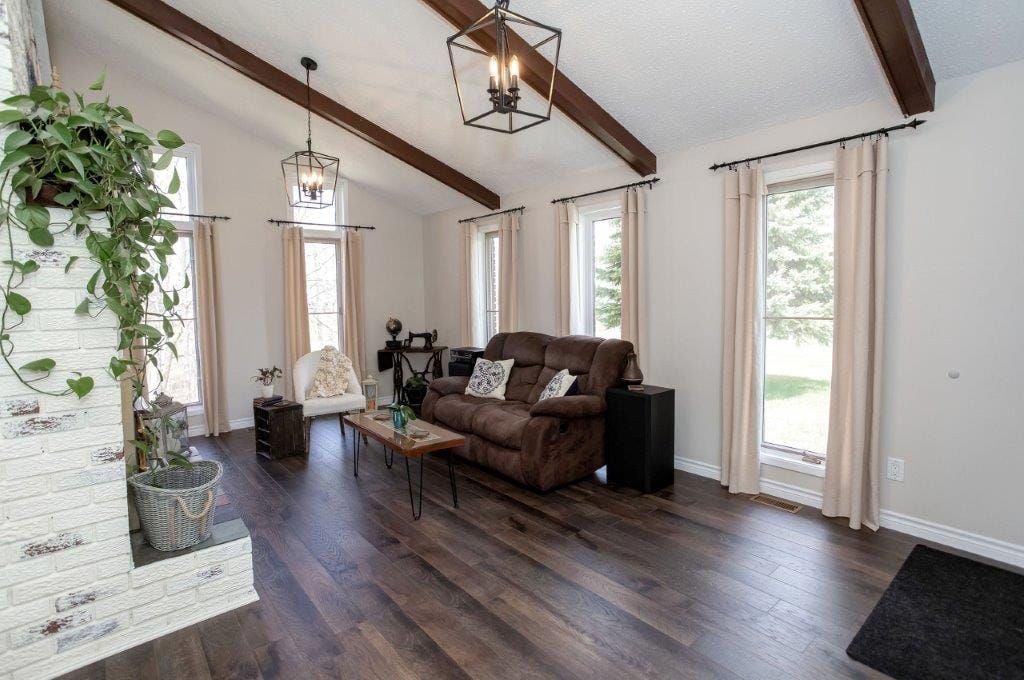 Living room with brown sofa, hardwood floors, and white fireplace.