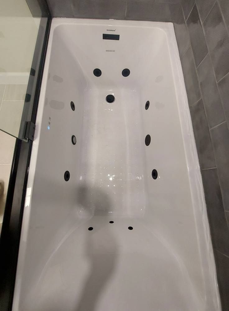 White jacuzzi tub with multiple jets.